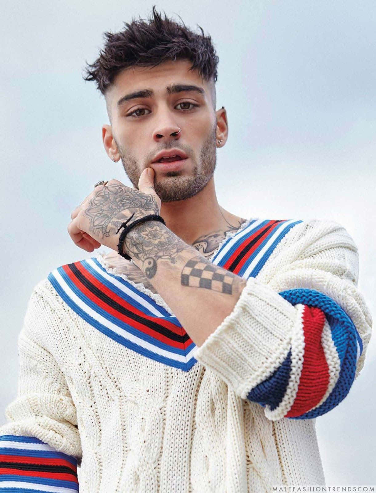 En mand med tatoveringer og en sweater