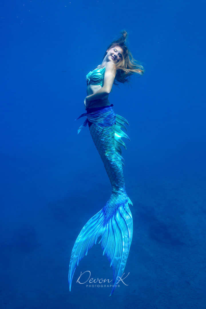 A Mermaid In Blue Swimsuit With Her Tail Out