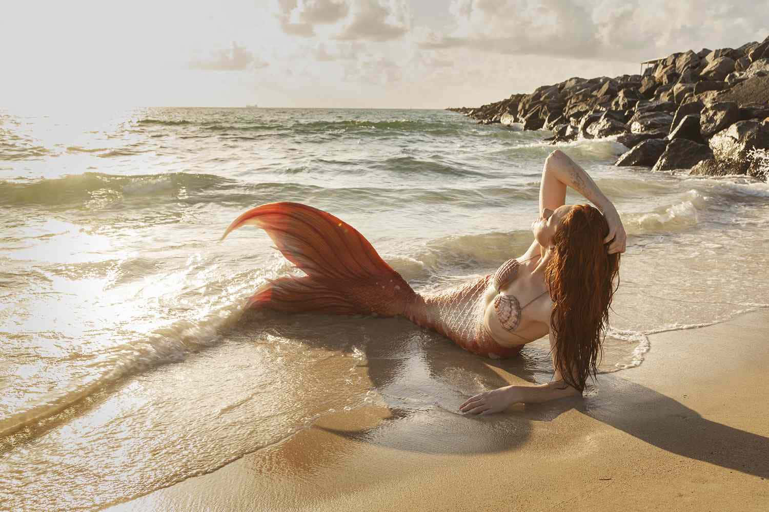 A beautiful mermaid enjoys the safety of the deep blue sea.
