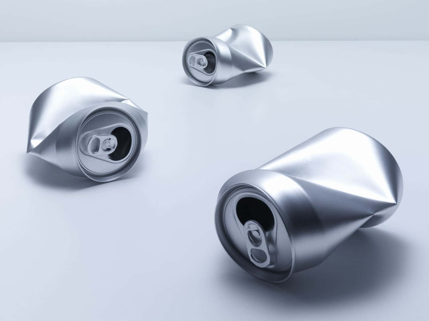 Three Cans Of Soda On A White Surface