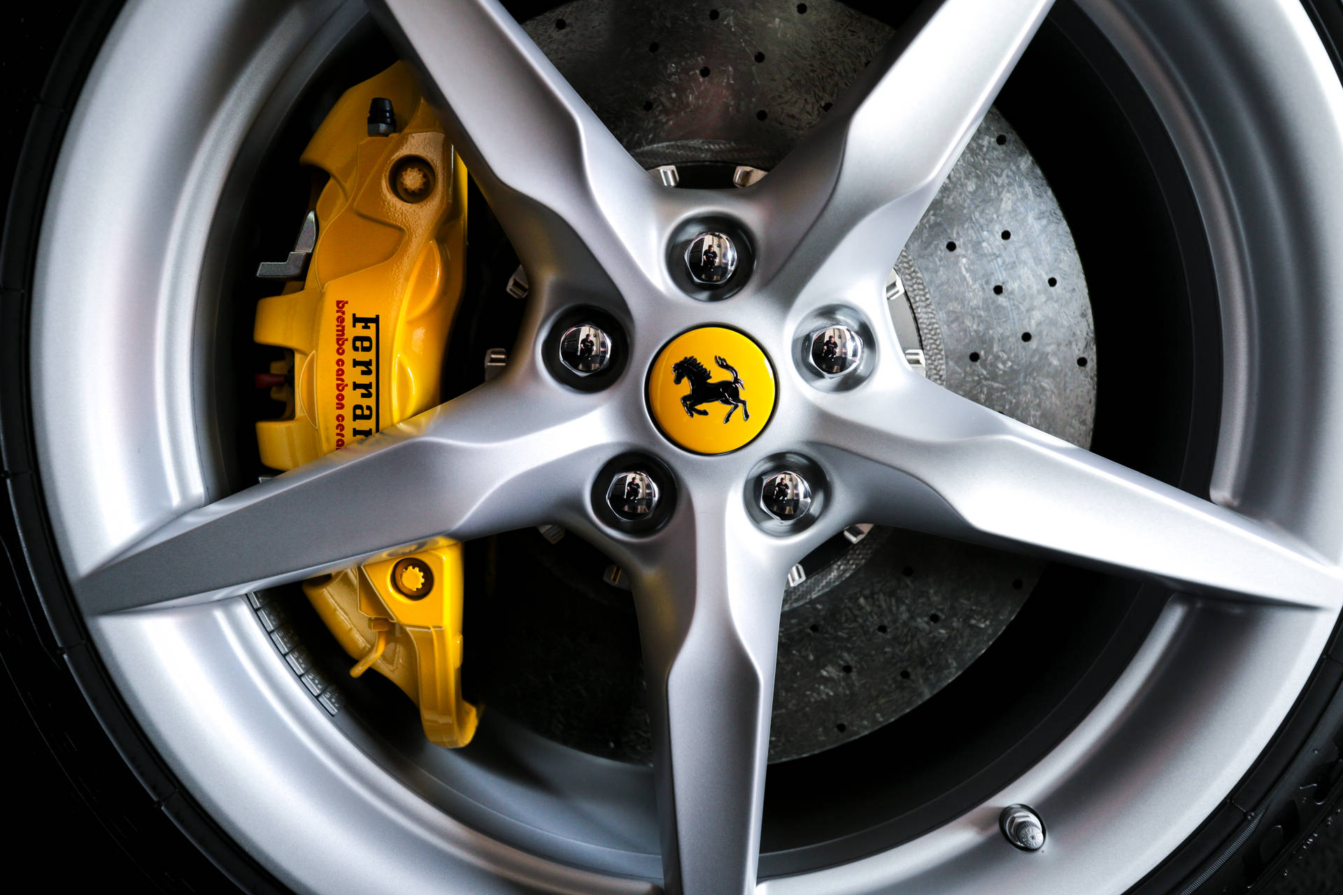 Metallic silver 5-spoke wheel of Ferrari sports car wallpaper.