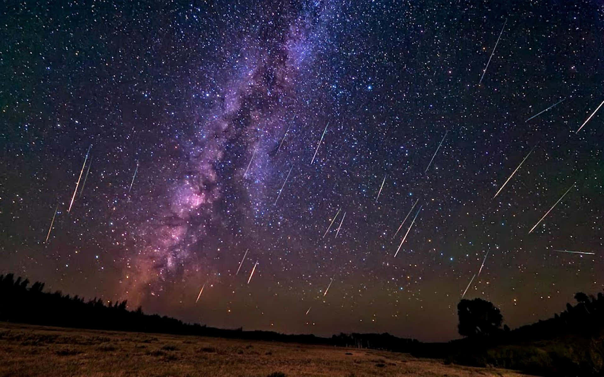 Awe-inspiring Meteor Shower in Night Sky Wallpaper