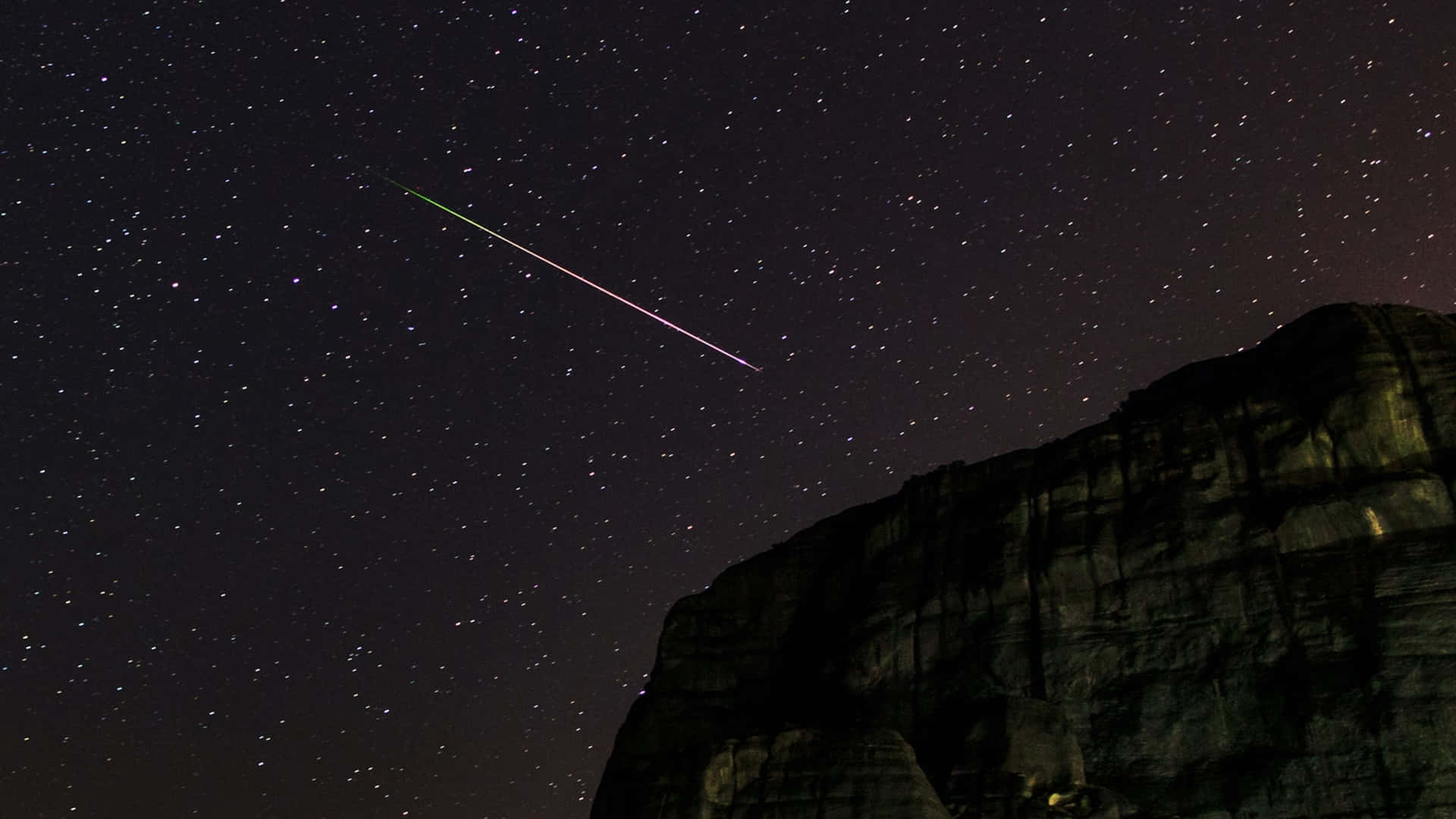 An image of a stunning glowing meteor streaking across the night sky