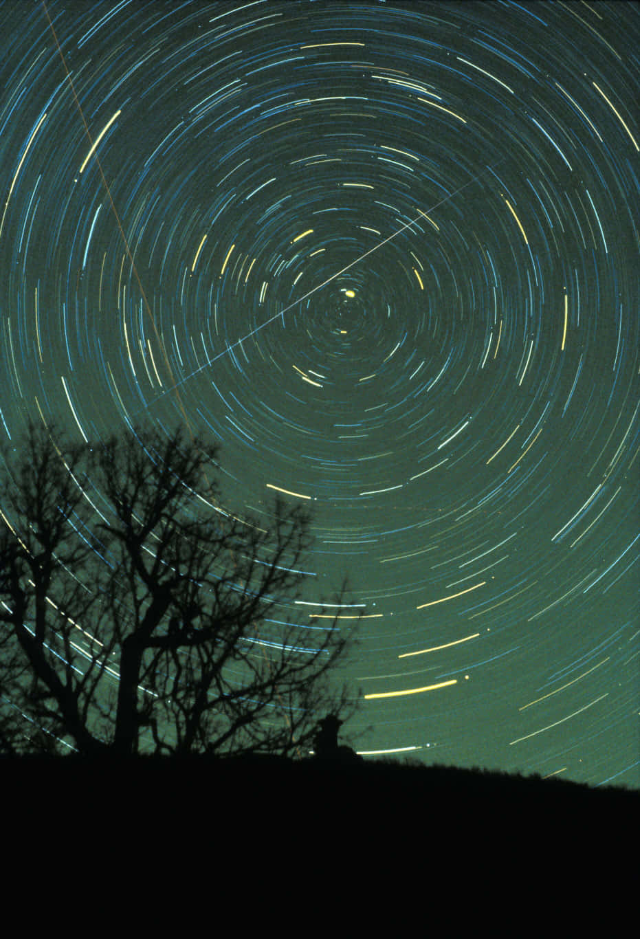 A brilliantly lit meteor streaks through the night sky
