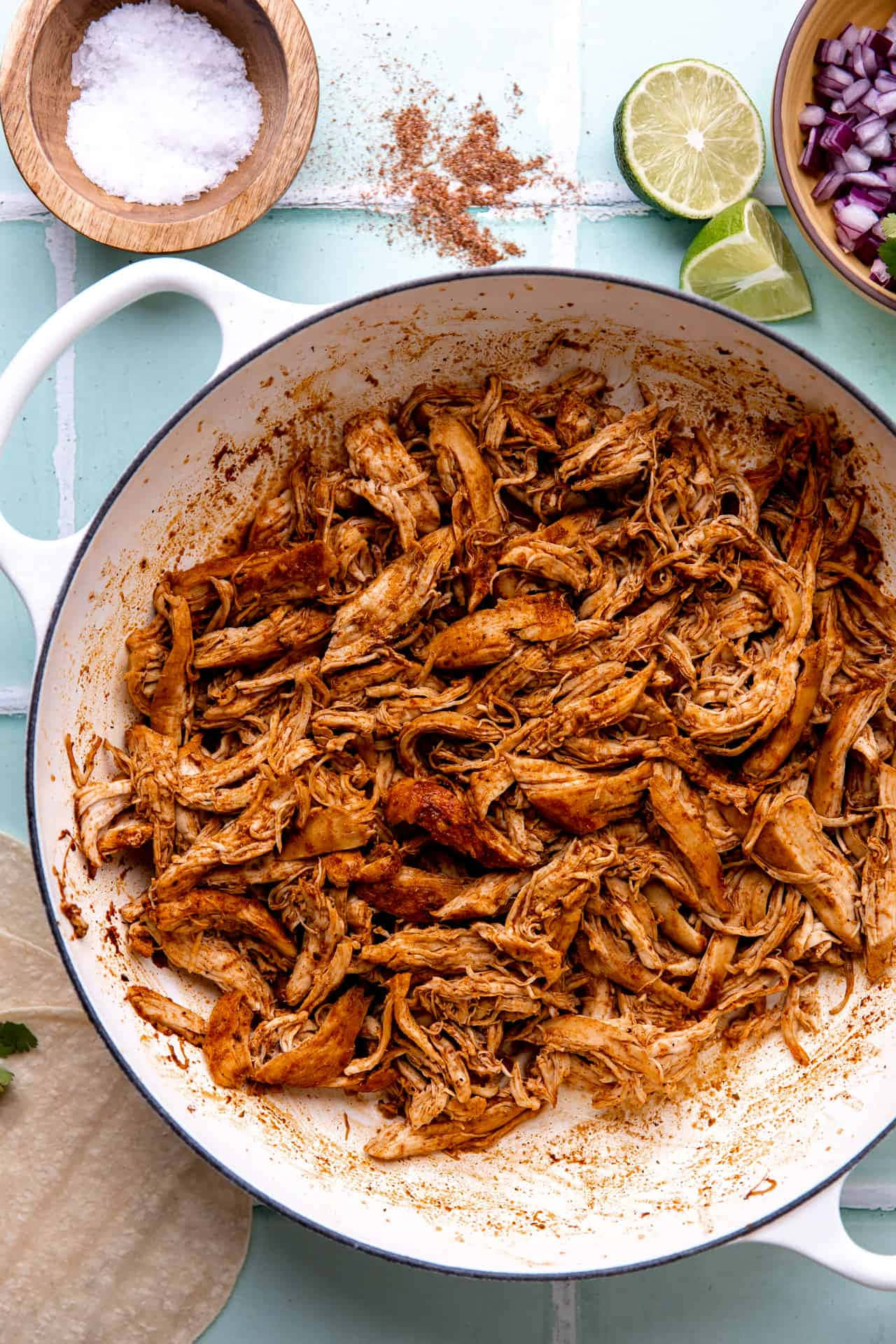 Shredded Chicken In A Pan With Spices And Limes