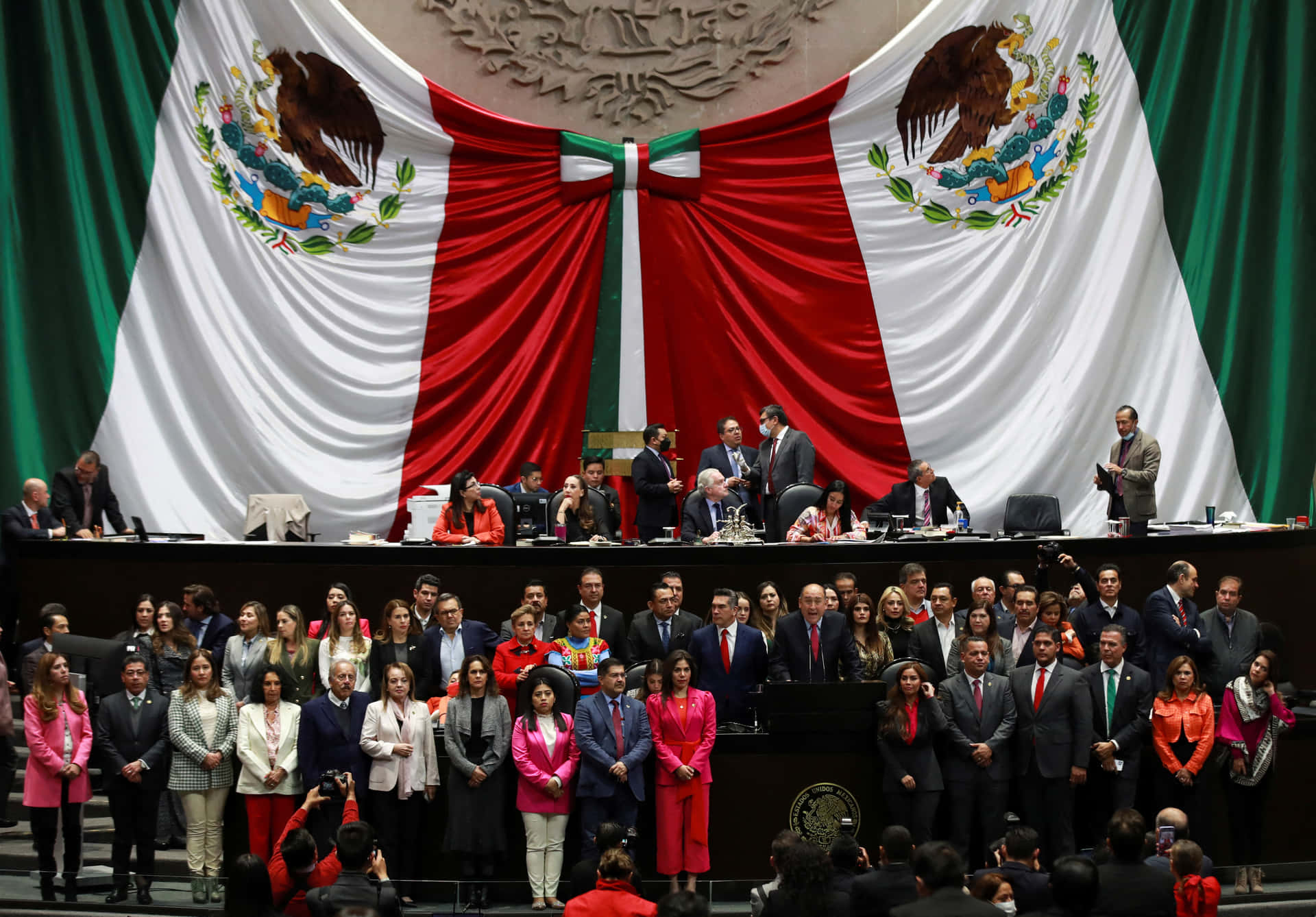 Einegruppe Von Menschen Steht Vor Einer Mexikanischen Flagge.