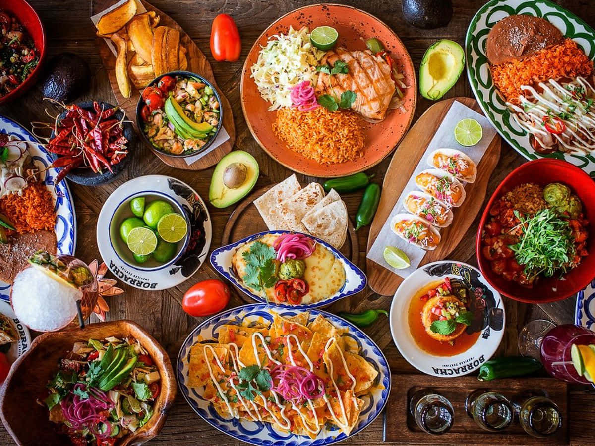 A Table Full Of Mexican Food On A Wooden Table