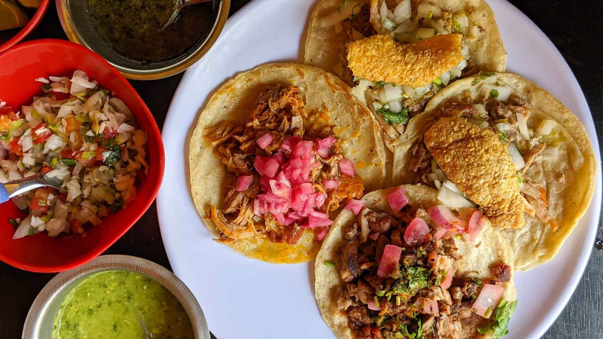 A Plate Of Tacos And Other Food On A Table