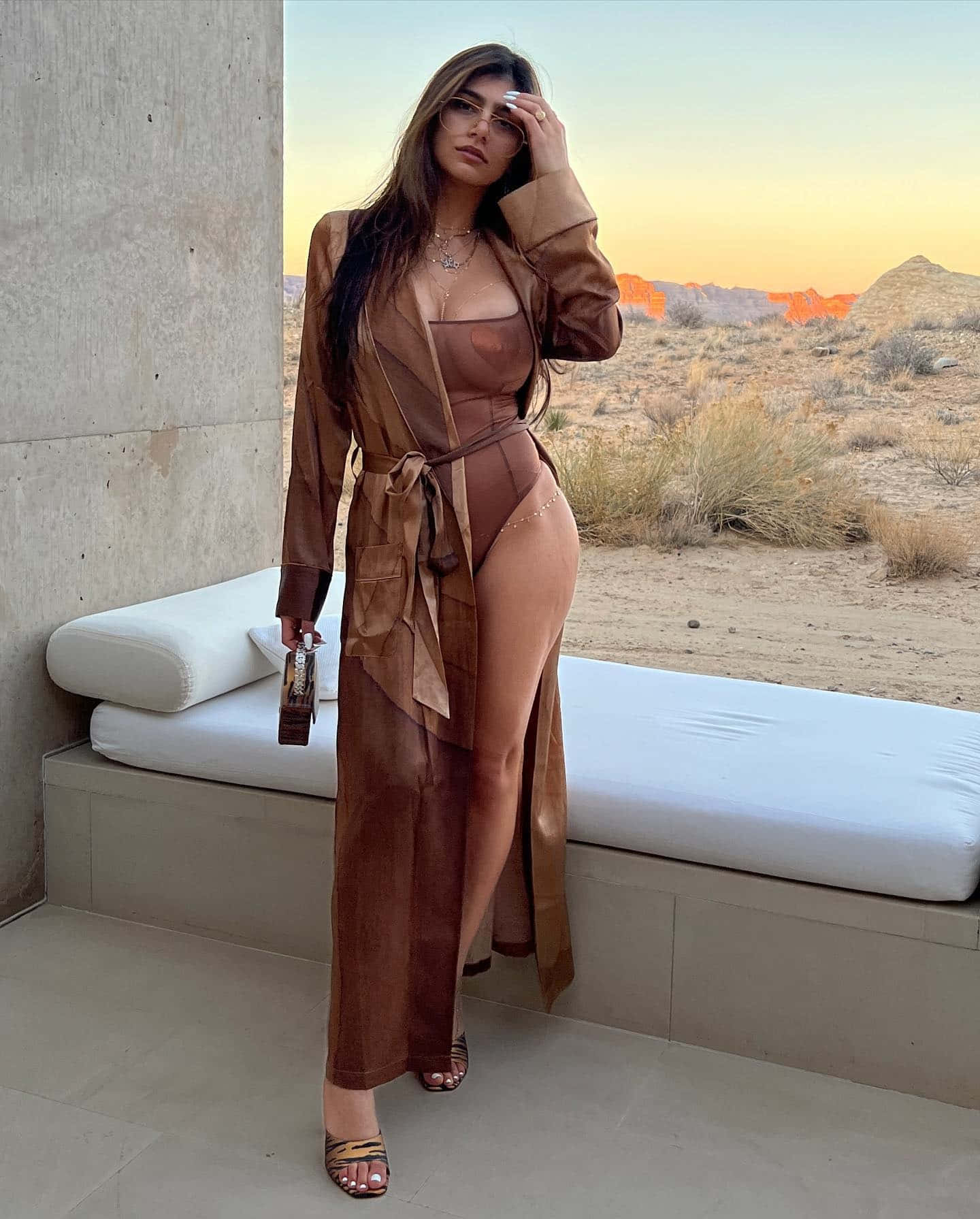 A Woman In A Brown Bodysuit Posing In The Desert