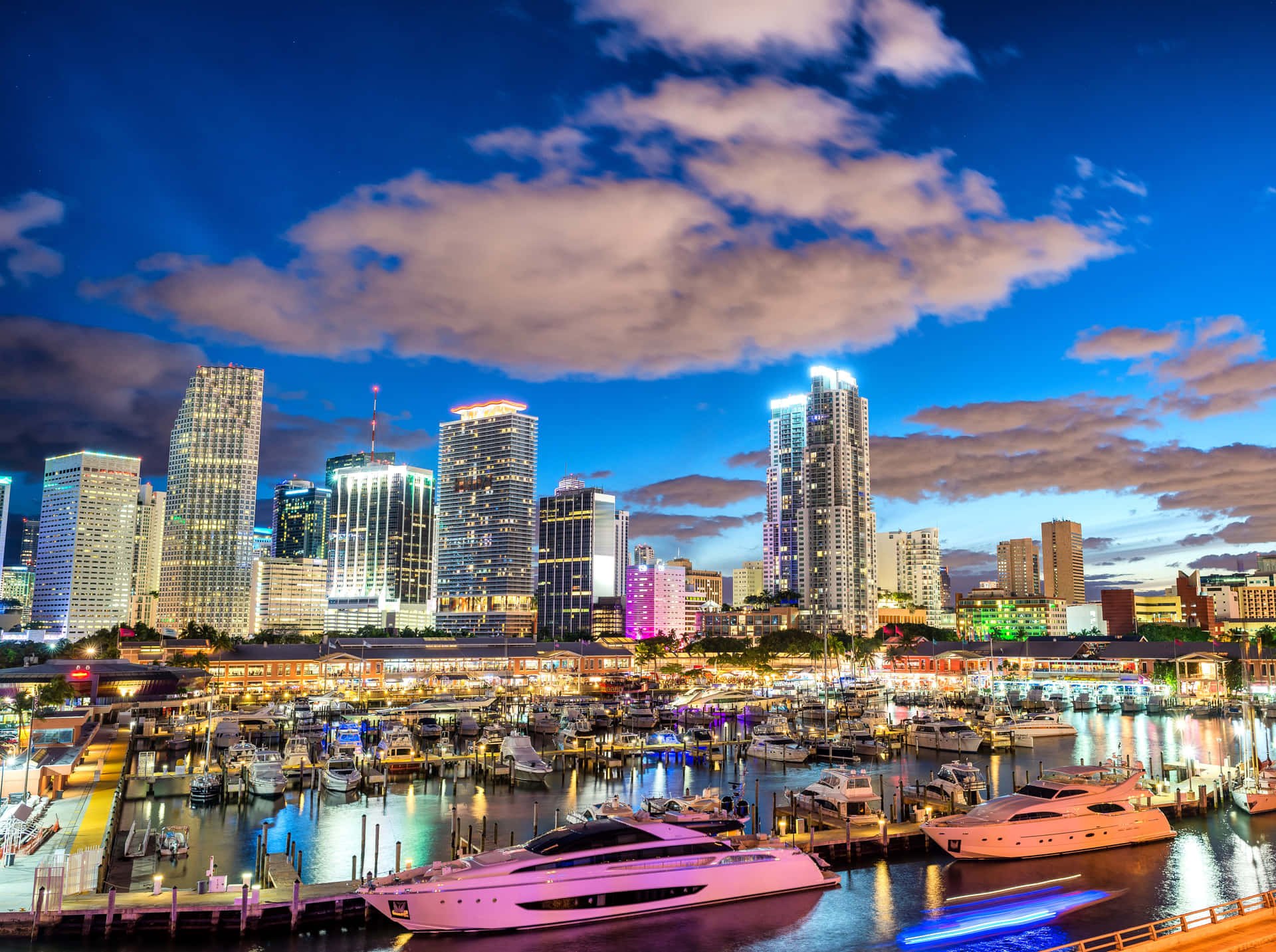 Miami City Skyline At Night With Boats Docked Wallpaper
