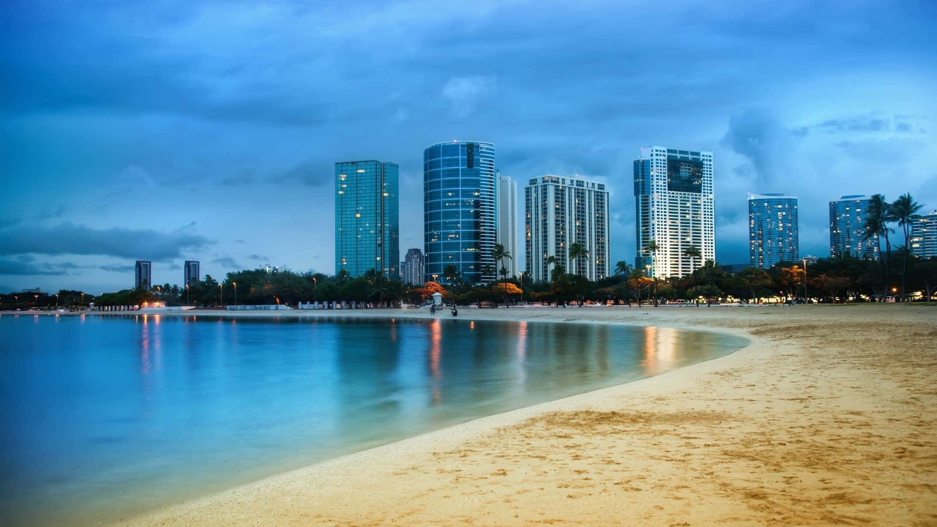 A Beach With Buildings And A Cloudy Sky