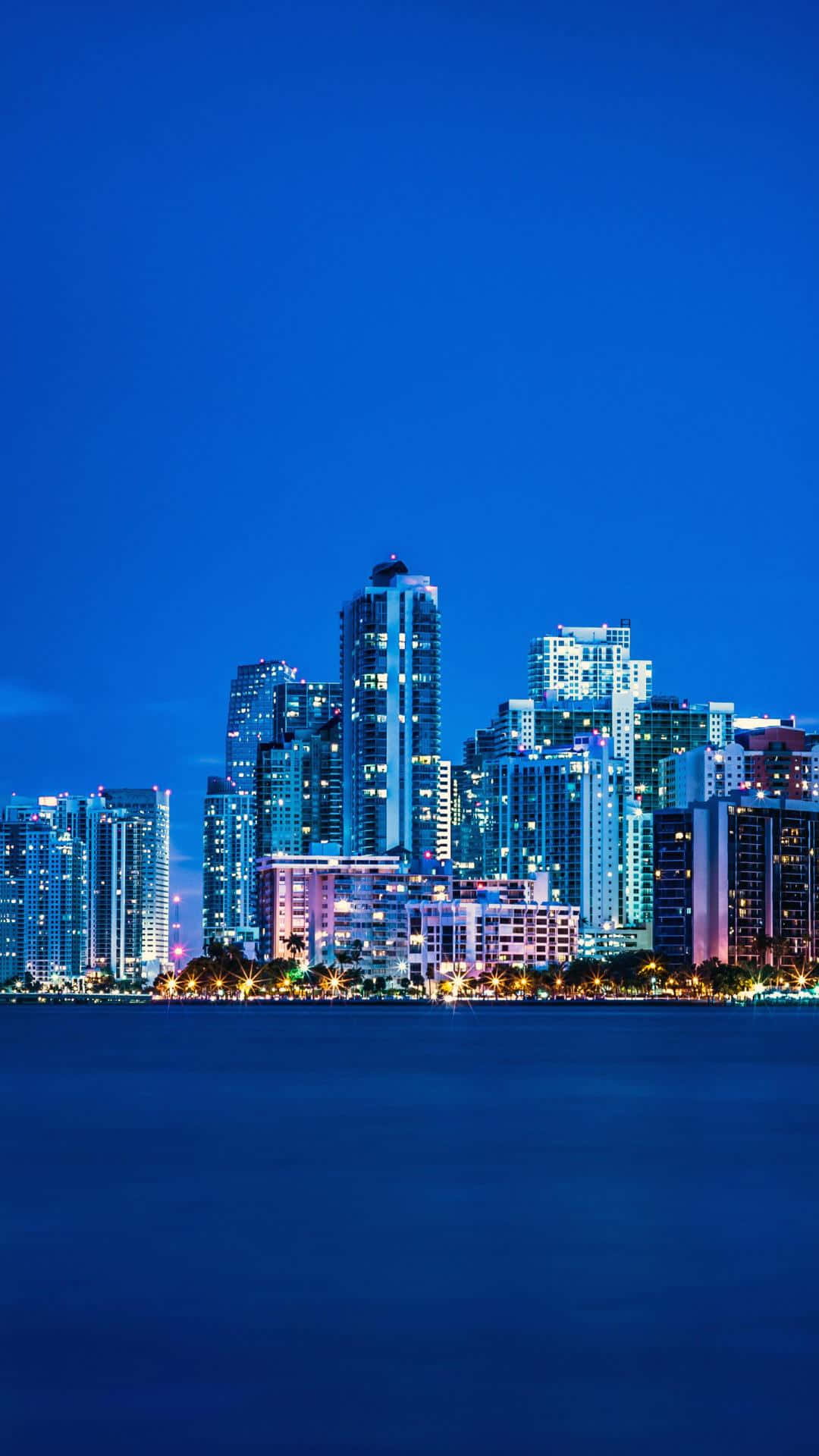 Fondode Pantalla De Miami Skyline Nocturno Con El Océano Azul Para Iphone. Fondo de pantalla