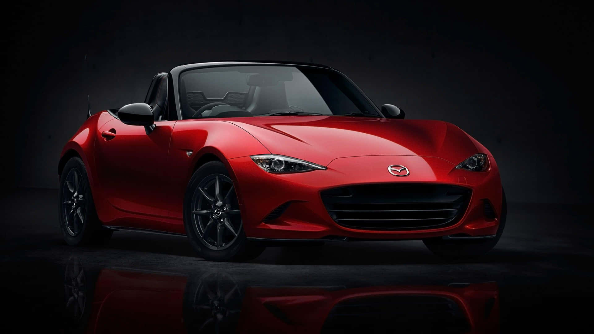 The Red Mazda Mx-5 Roadster Is Shown In A Dark Room Wallpaper