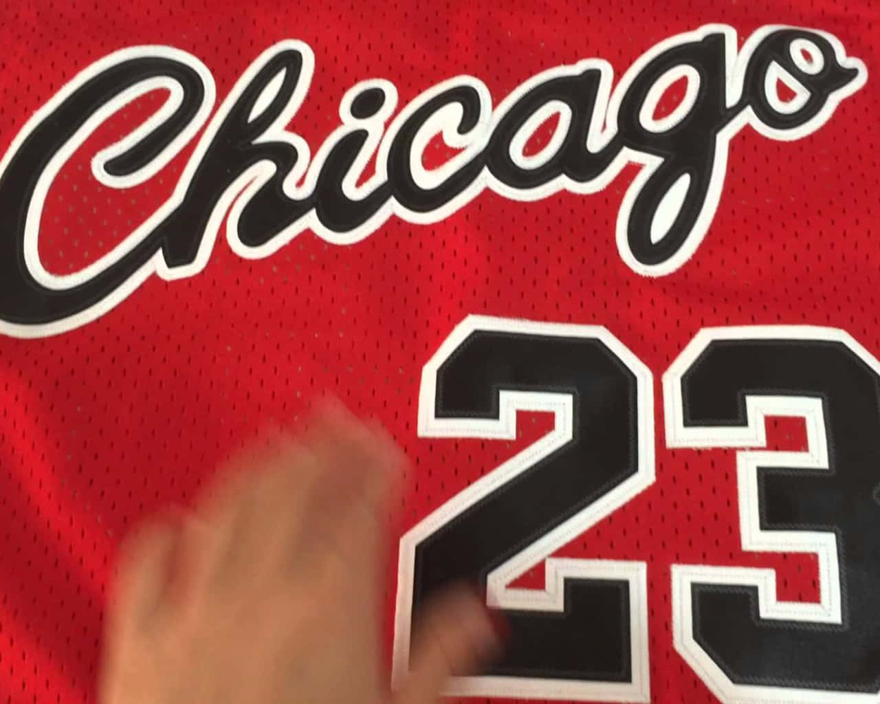 A Person Is Holding Up A Chicago Bulls Jersey Wallpaper