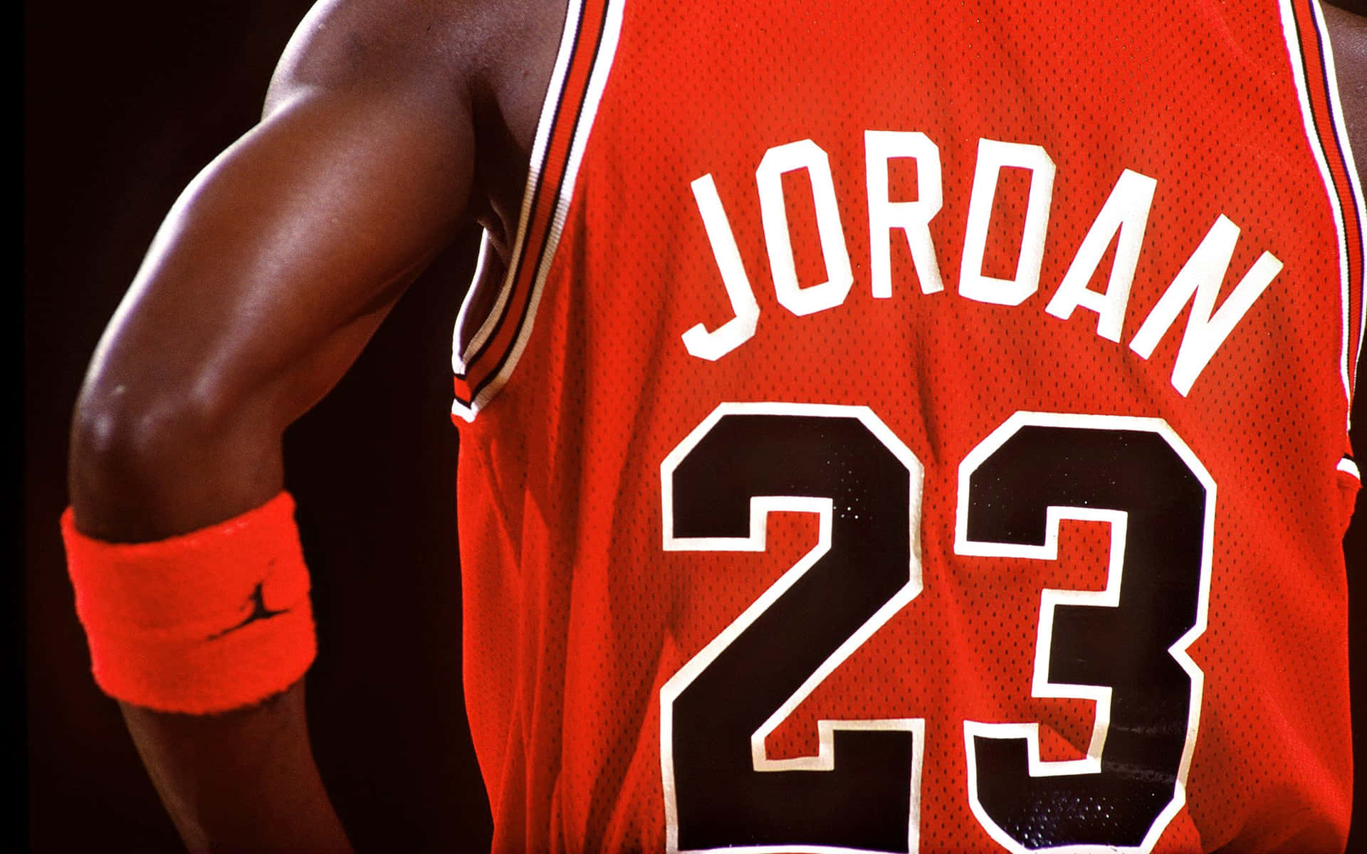 Download An iconic Michael Jordan jersey hangs off a basketball hoop,  creating a powerful connection between the GOAT and the game of basketball.  Wallpaper