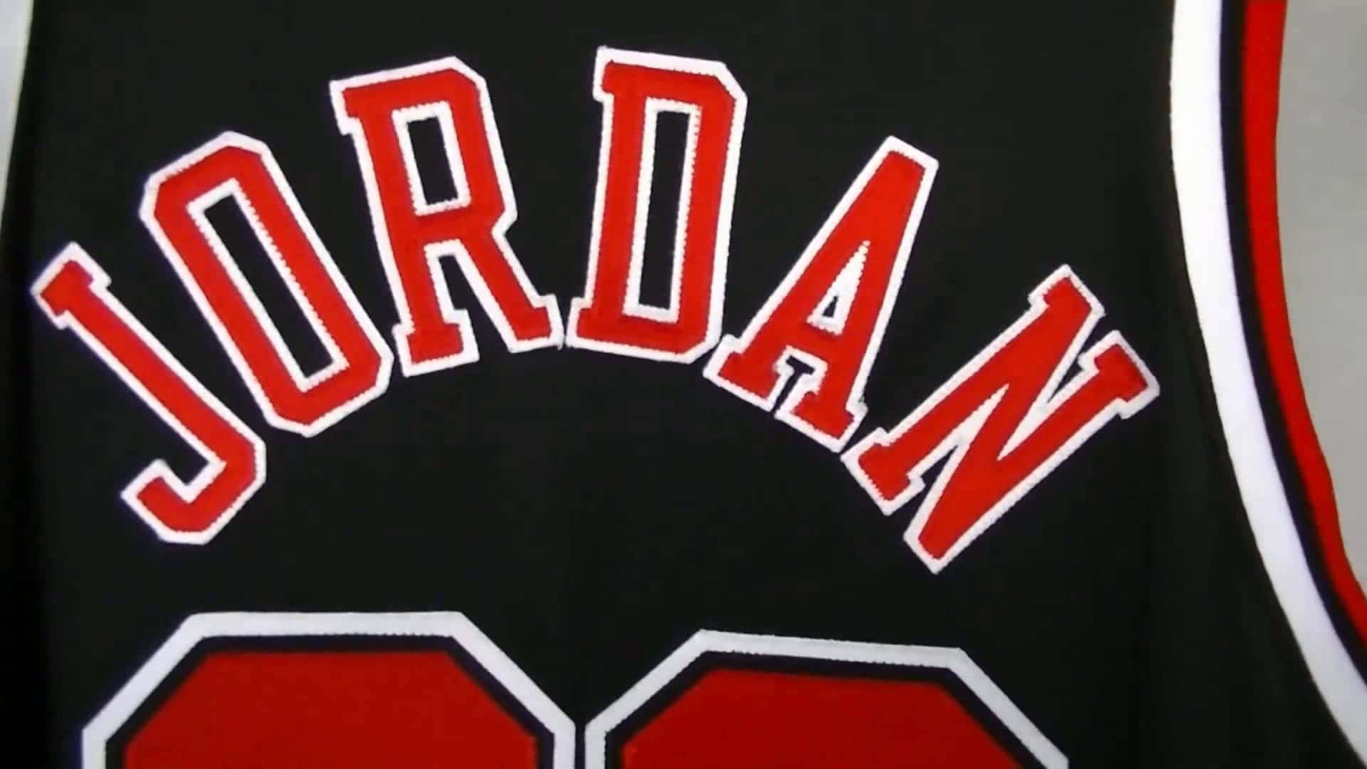 Jordan's Jersey Is Shown On A Black Background Wallpaper