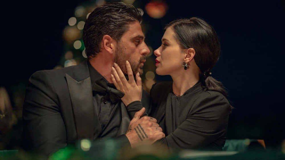A Man And Woman Kissing In A Black Suit