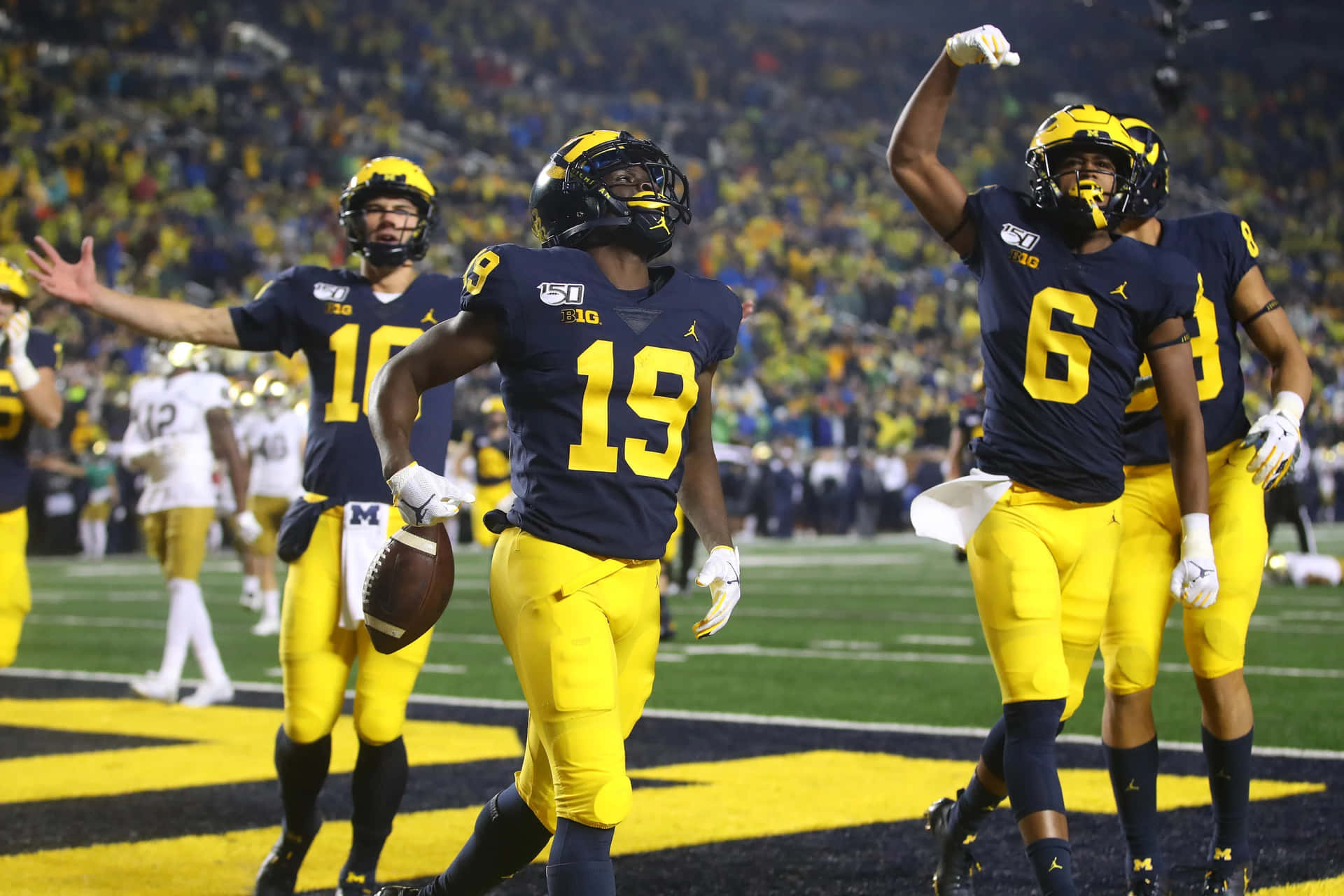 Michigan Wolverines Football Players Celebrate After A Touchdown Wallpaper