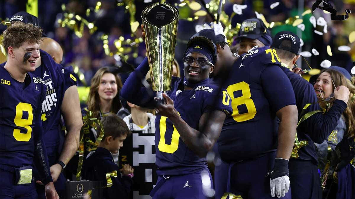 Michigan Football Team Celebrating Victory With Trophy Wallpaper