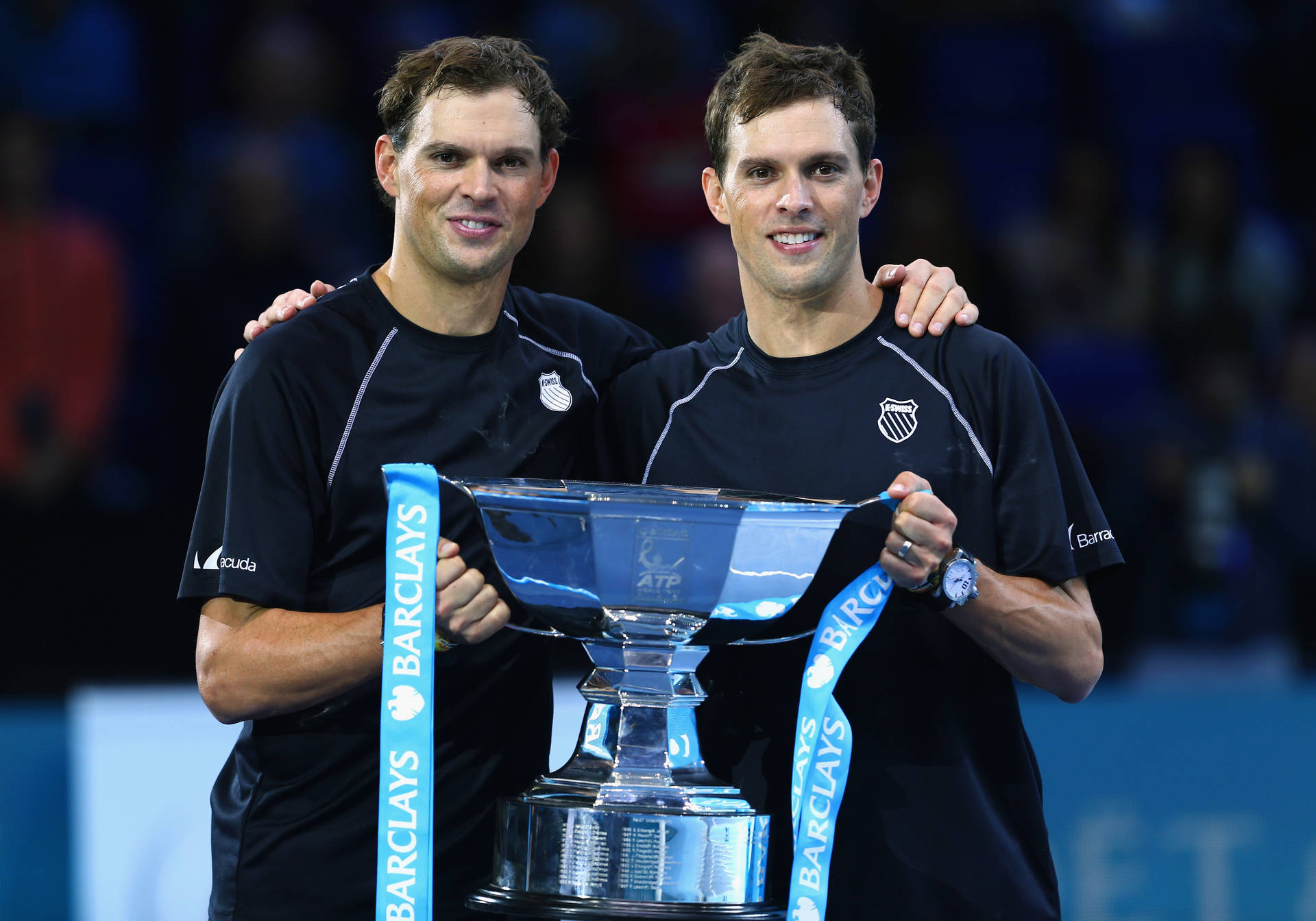 Brothers Bob and Mike Bryan Holding Winning Tennis Trophy Wallpaper