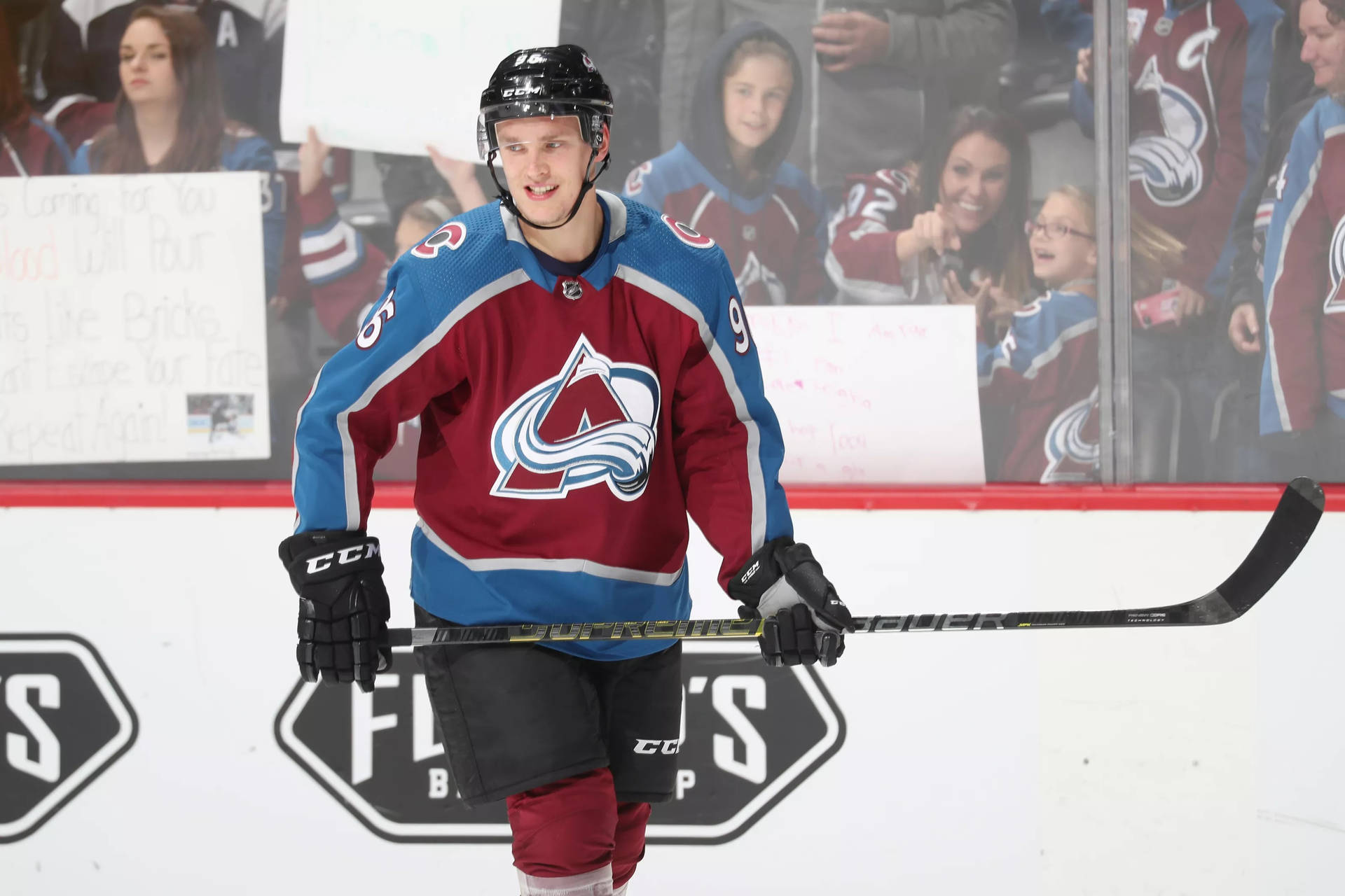 Mikko Rantanen Holding Hockey Stick With Both Hands While Smiling Wallpaper