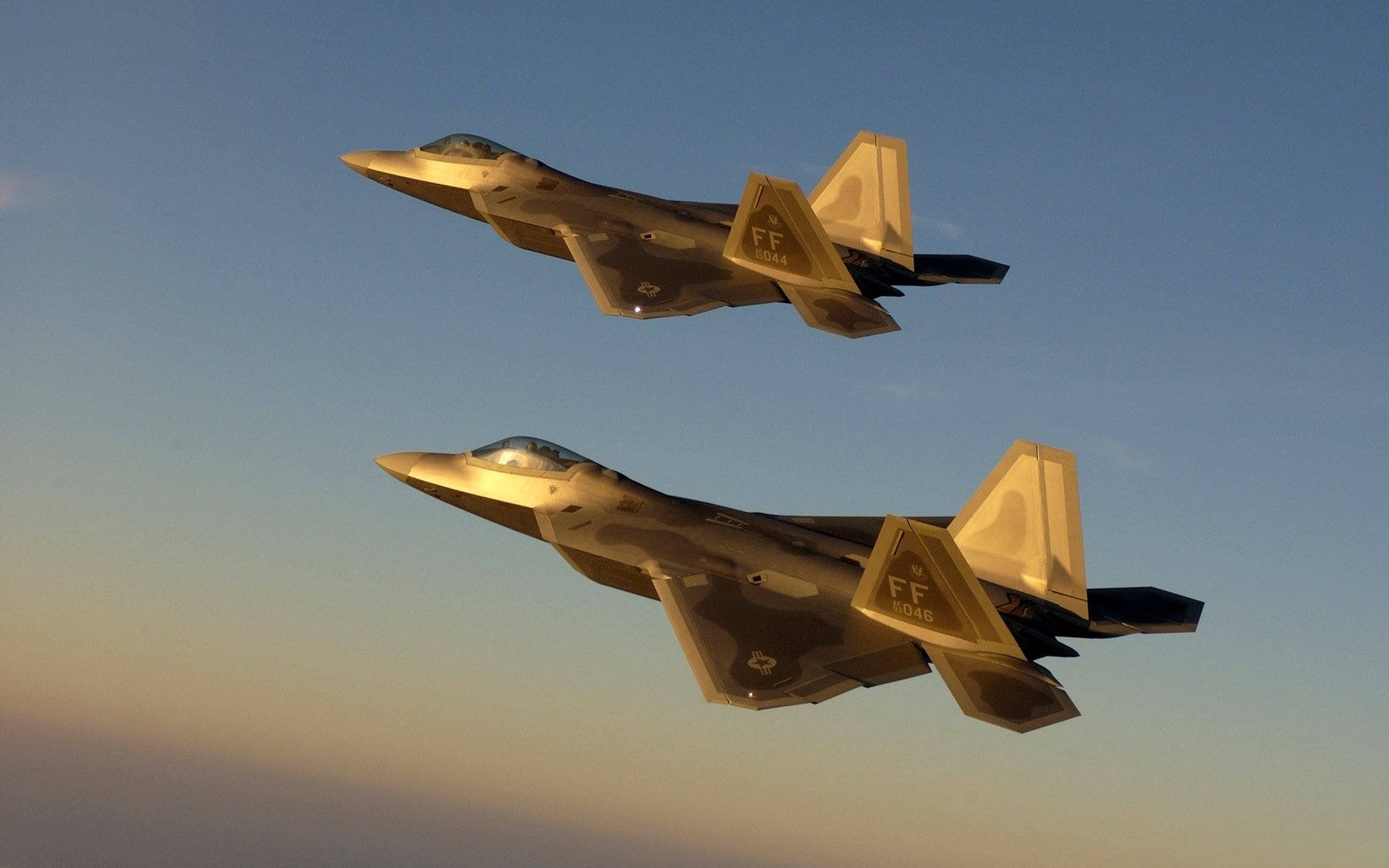 Et eskadrille af amerikanske militærjets flyver i formation over et ørkenlandskab. Wallpaper