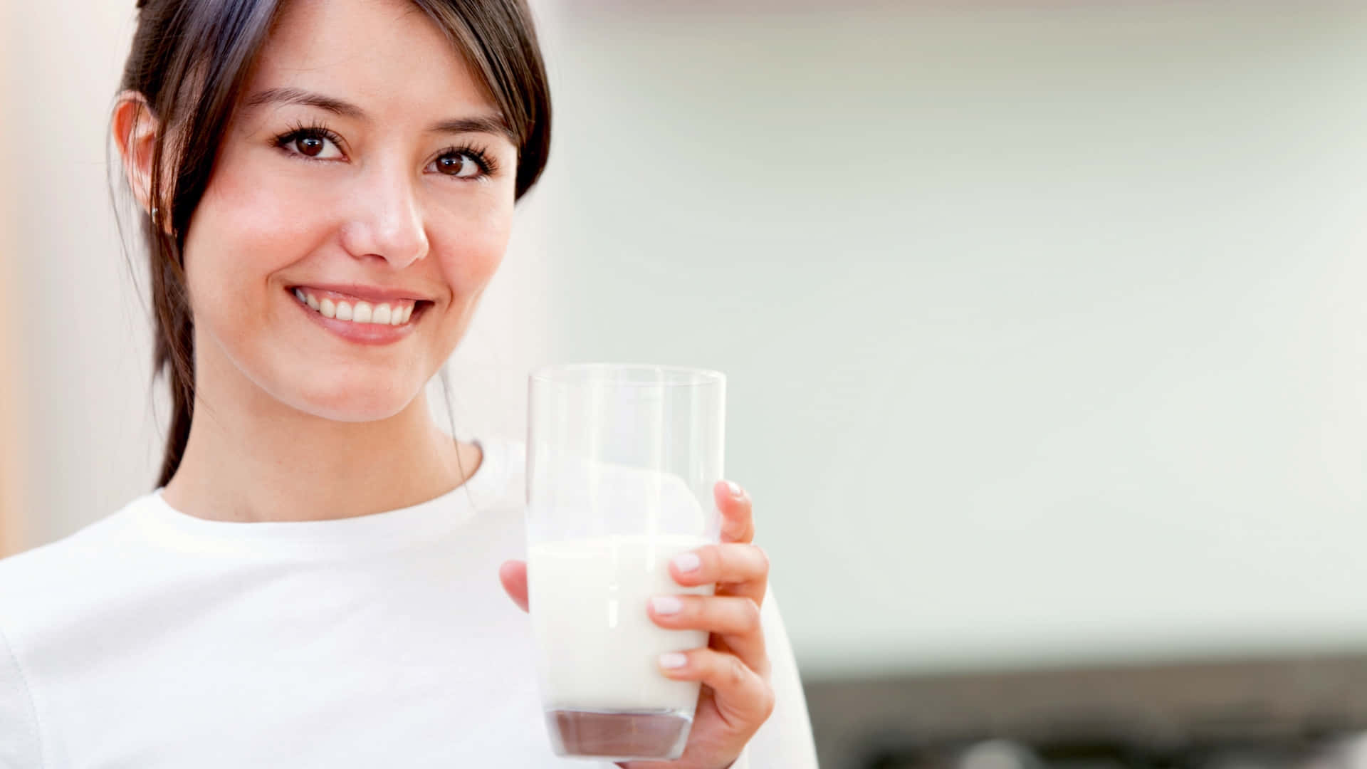 A Woman Holding A Glass Of Milk