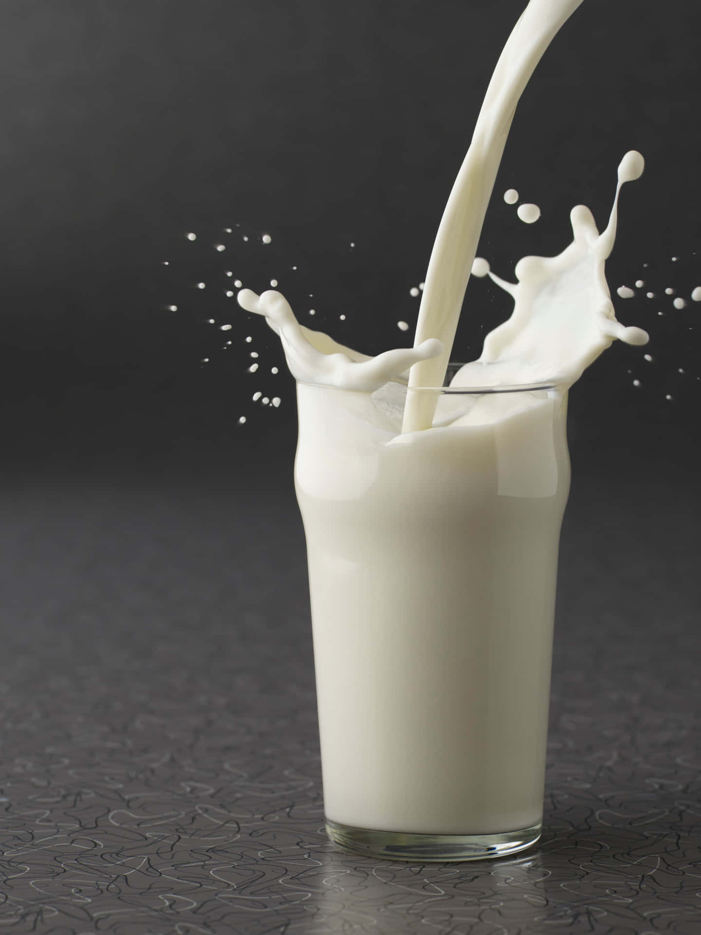 A Glass Of Milk Is Being Poured Into A Glass