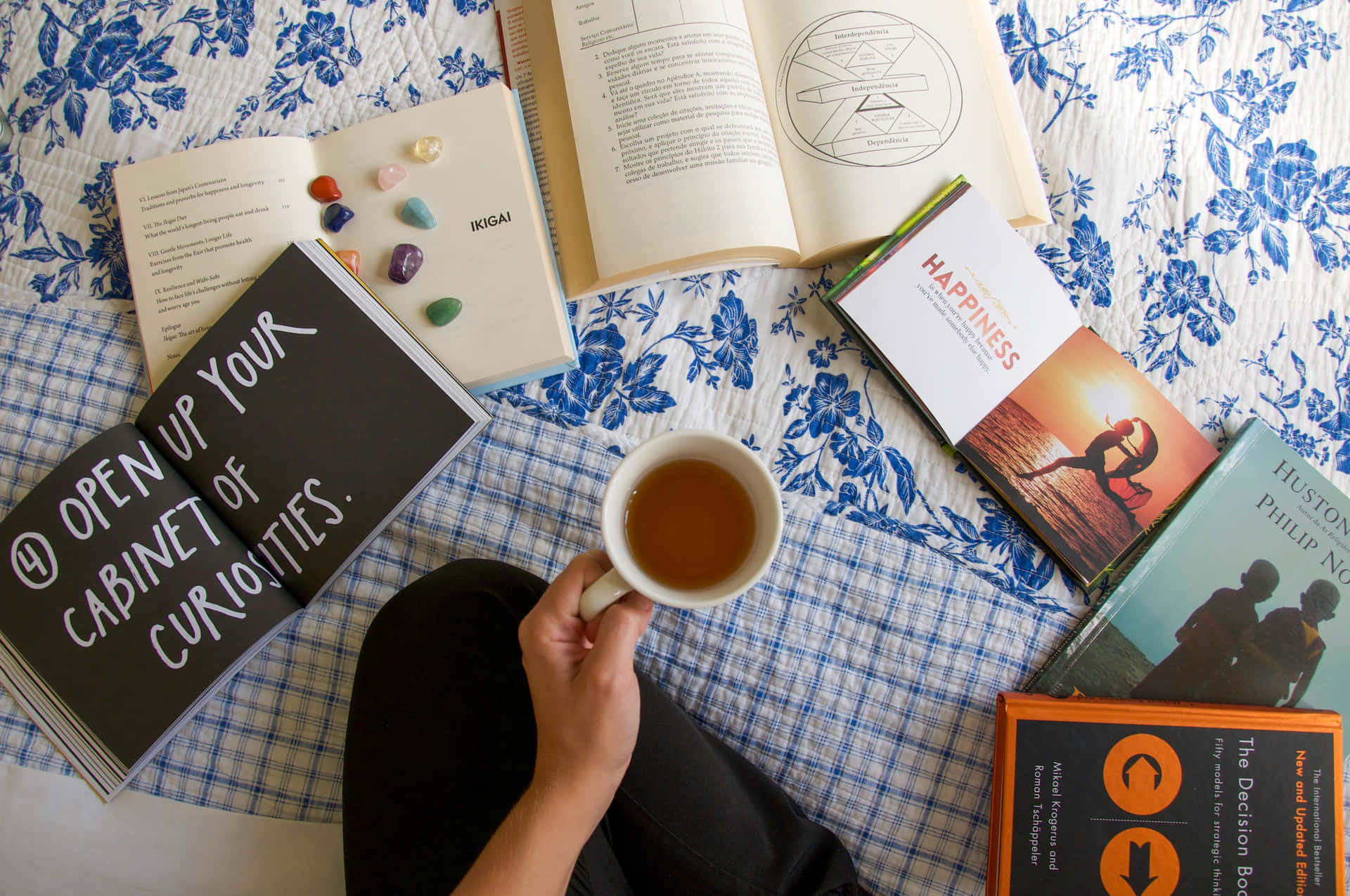 A Woman Is Sitting On A Bed With Books And A Cup Of Tea Wallpaper