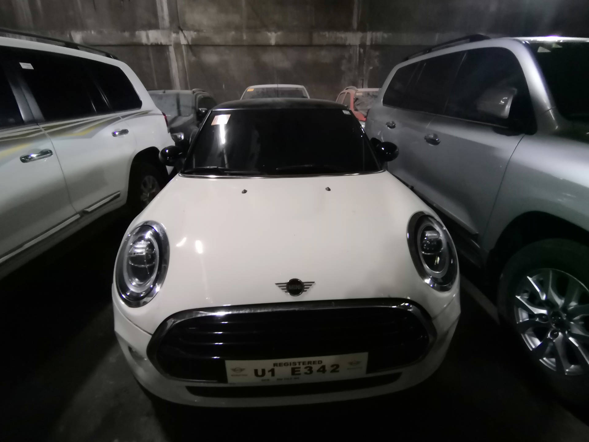 Mini White Car In Between Two Cars Wallpaper