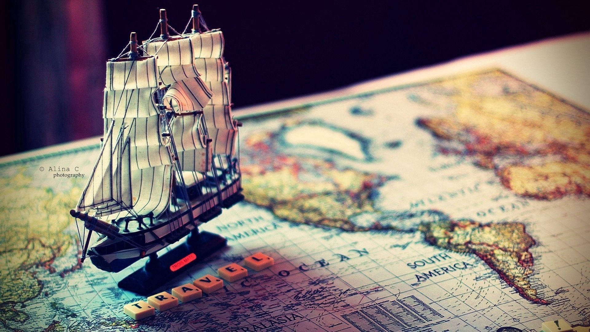 A boat sails across the globe Wallpaper