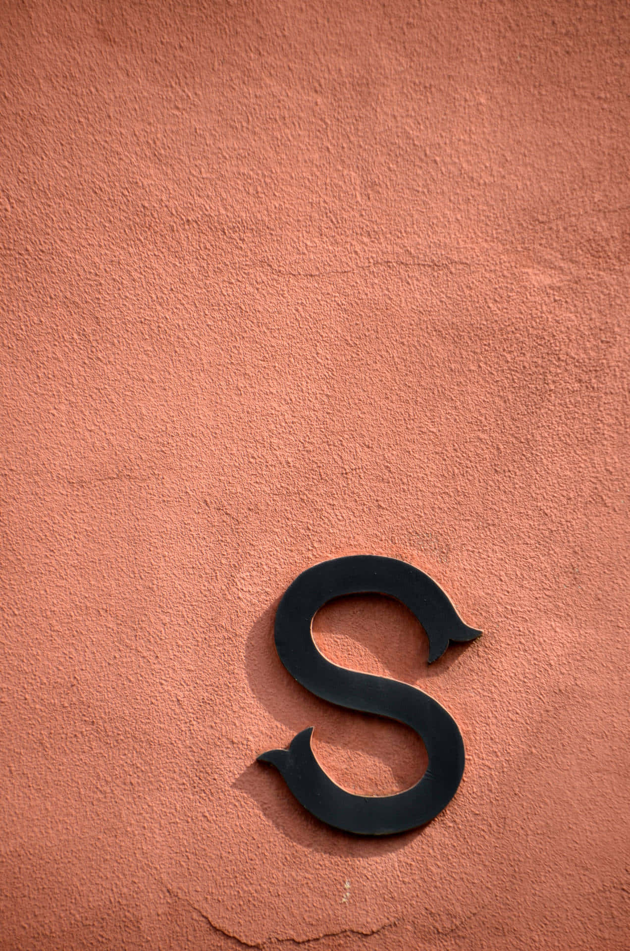 Minimalist Black S Letteron Red Wall.jpg Wallpaper