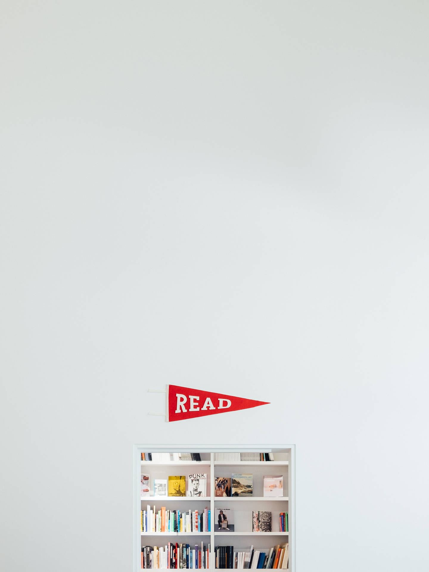 Minimalist books on a white shelf wallpaper