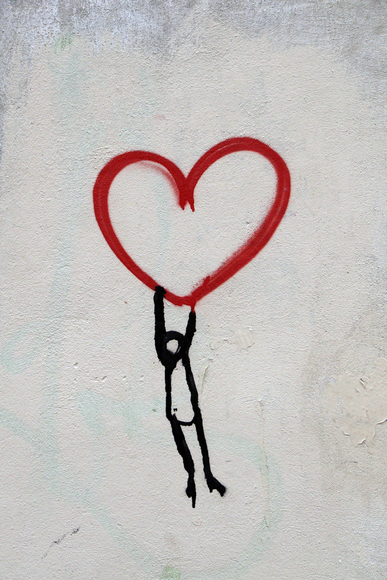 Minimalist art of tiny black stick man holding onto a big red heart made of string.
