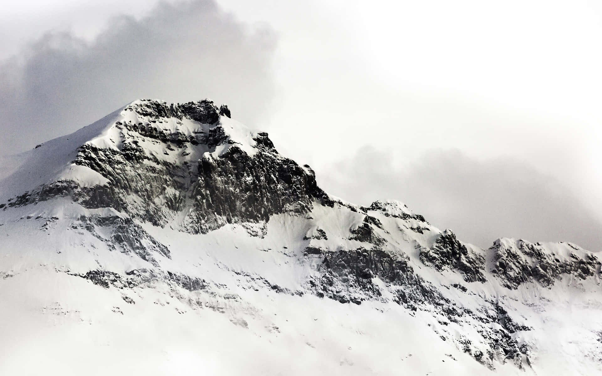 En person står på ski ned ad en sne-dækket bjerg. Wallpaper