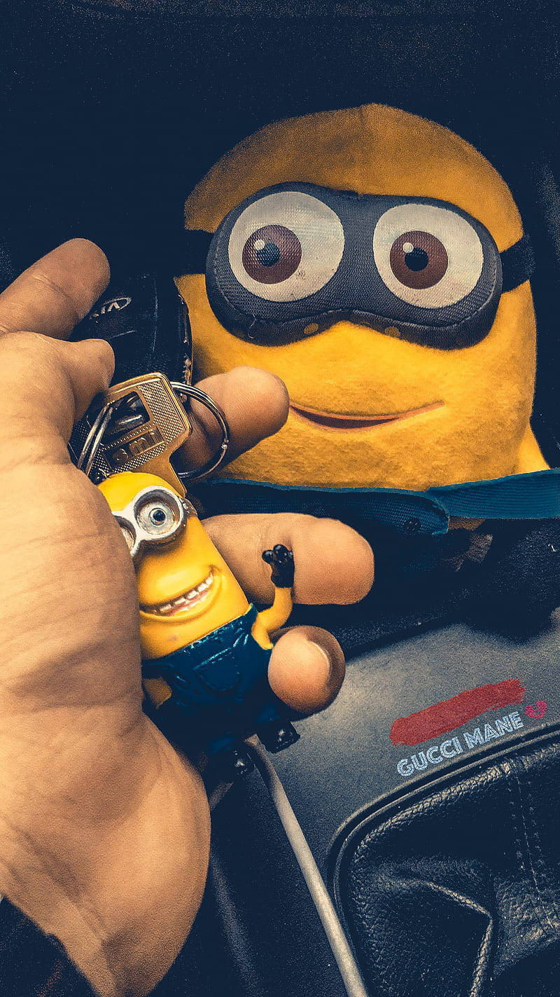 A Person Holding A Minion Keychain Wallpaper