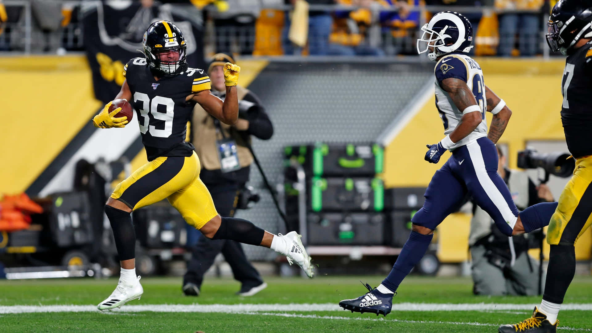 Minkahfitzpatrick Corriendo Con El Balón De Fútbol Americano De Los Pittsburgh Steelers. Fondo de pantalla
