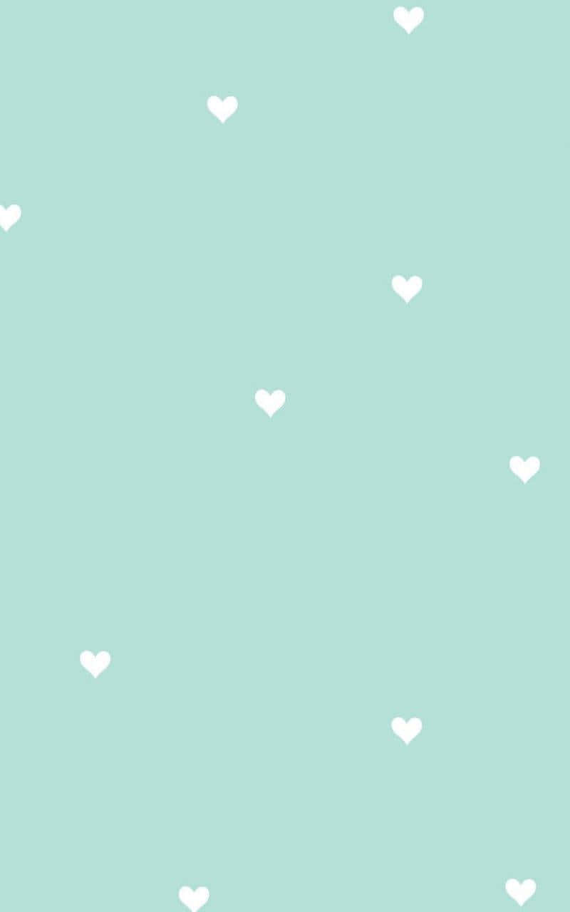 Heart cushions of pastel mint green color in strewn on a white background. Wallpaper