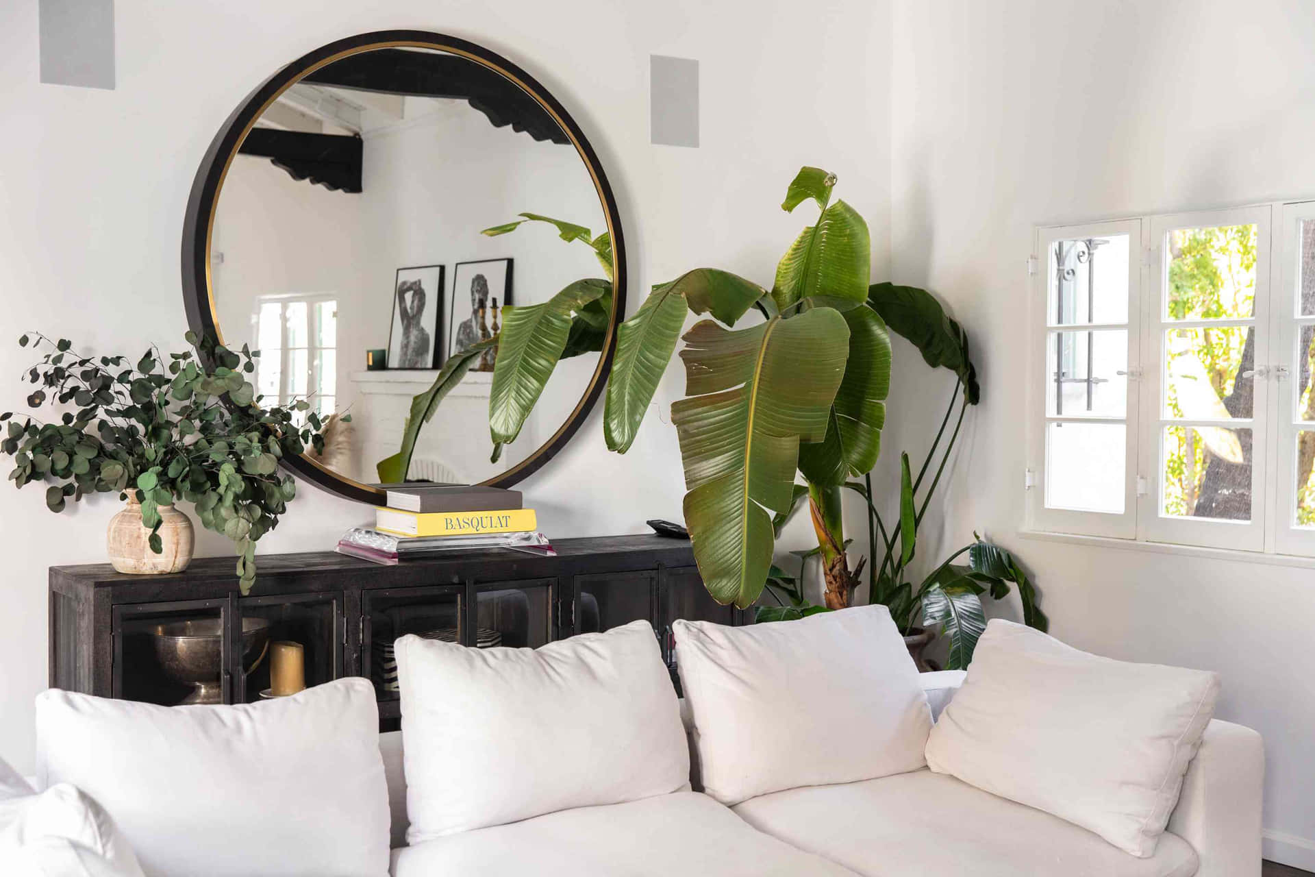A White Couch And A Large Mirror In A Living Room