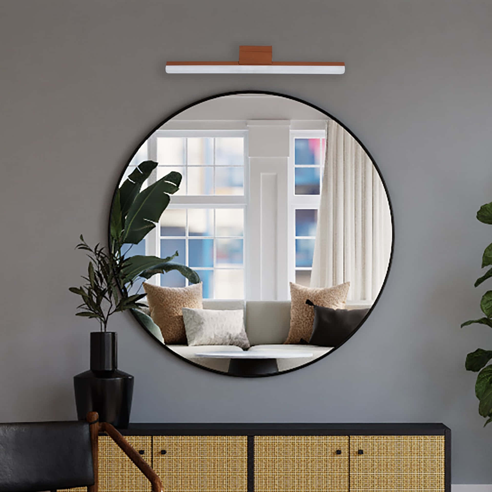 A Round Mirror Is Hanging Above A Black Cabinet