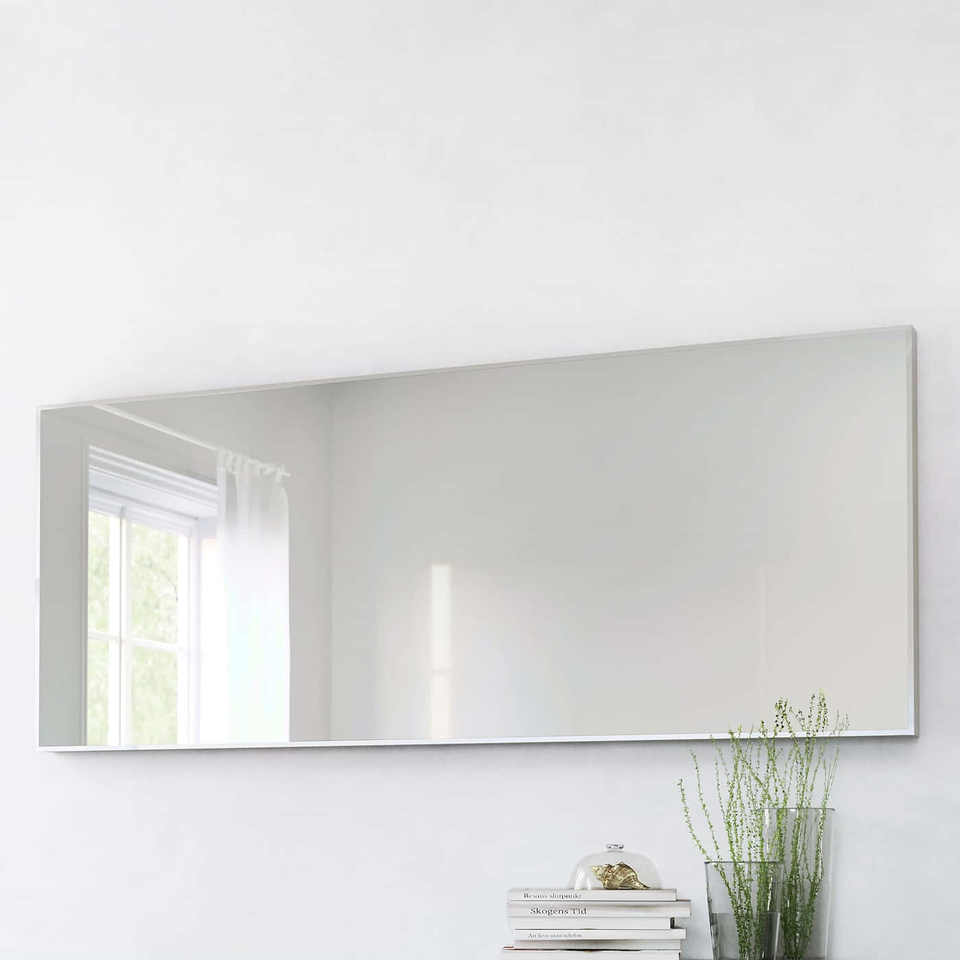 A Large Mirror Is Placed On A White Wall