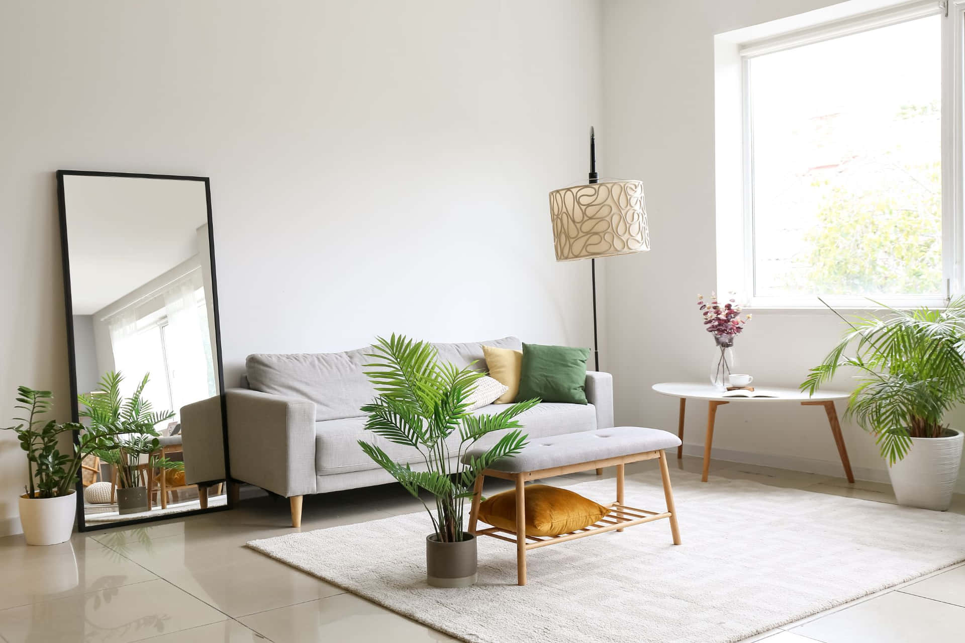 A Living Room With A Couch, A Mirror And Plants