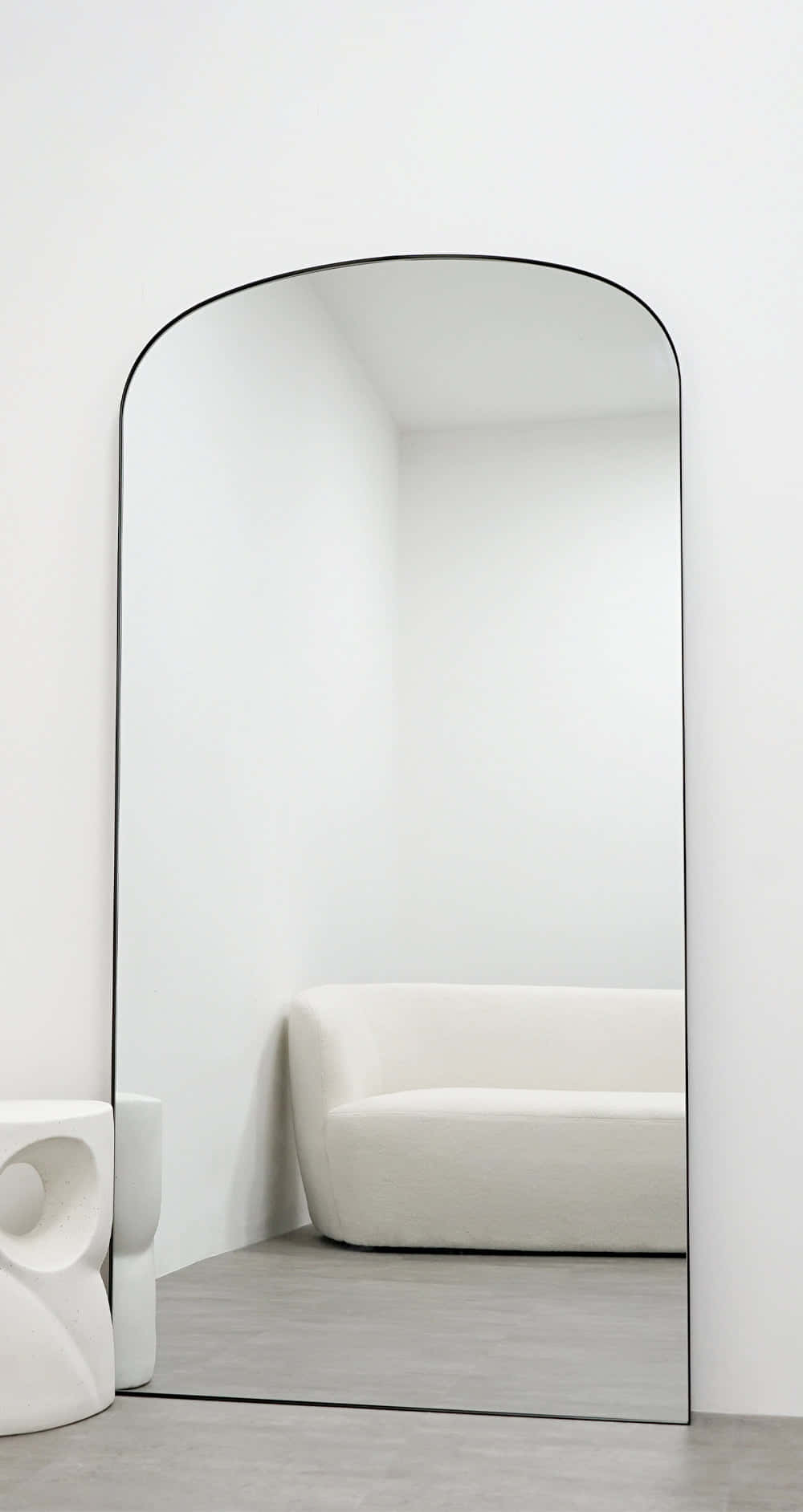 A White Couch And Mirror In A Room