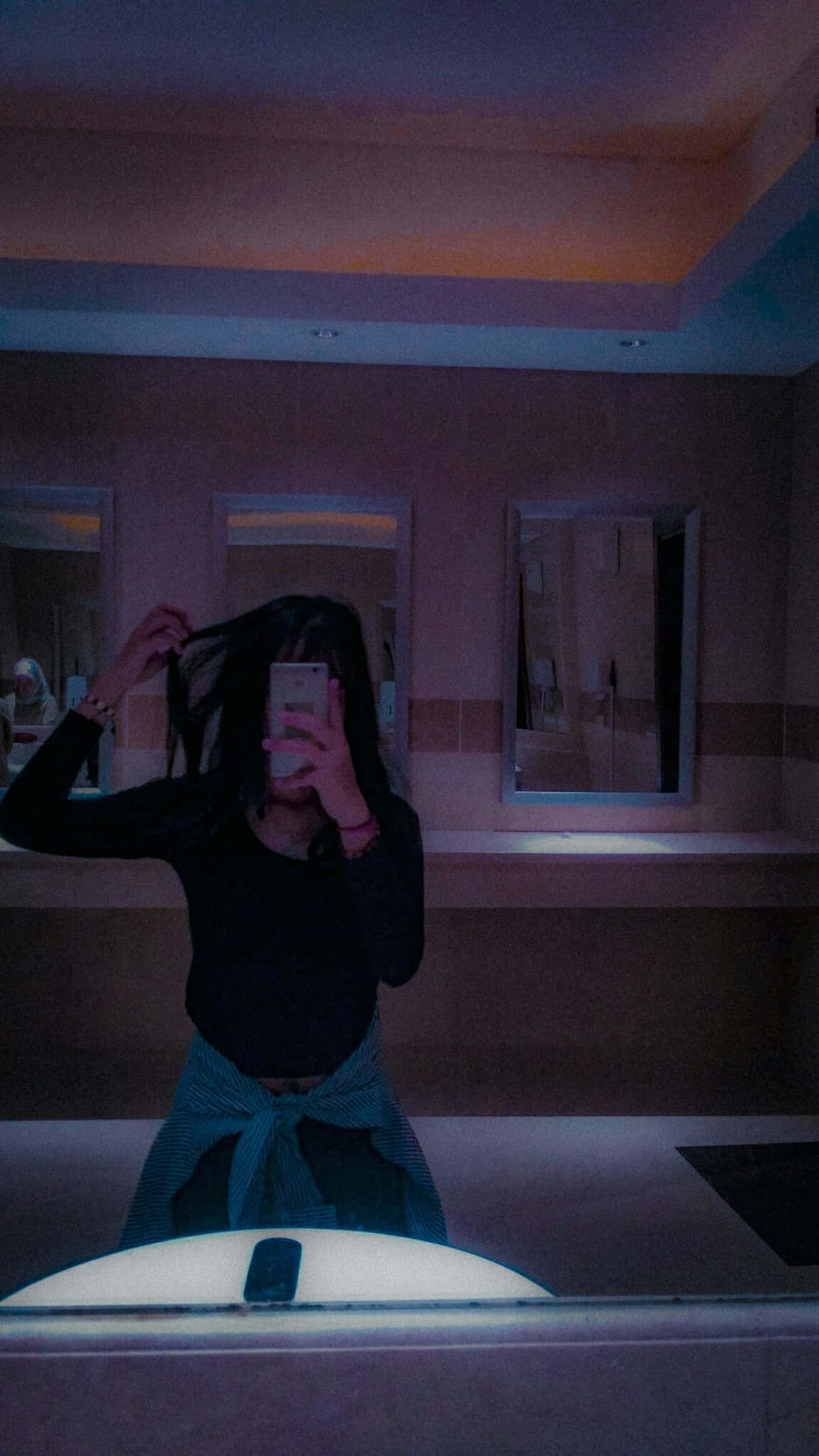 A Woman Is Taking A Selfie In A Bathroom Mirror