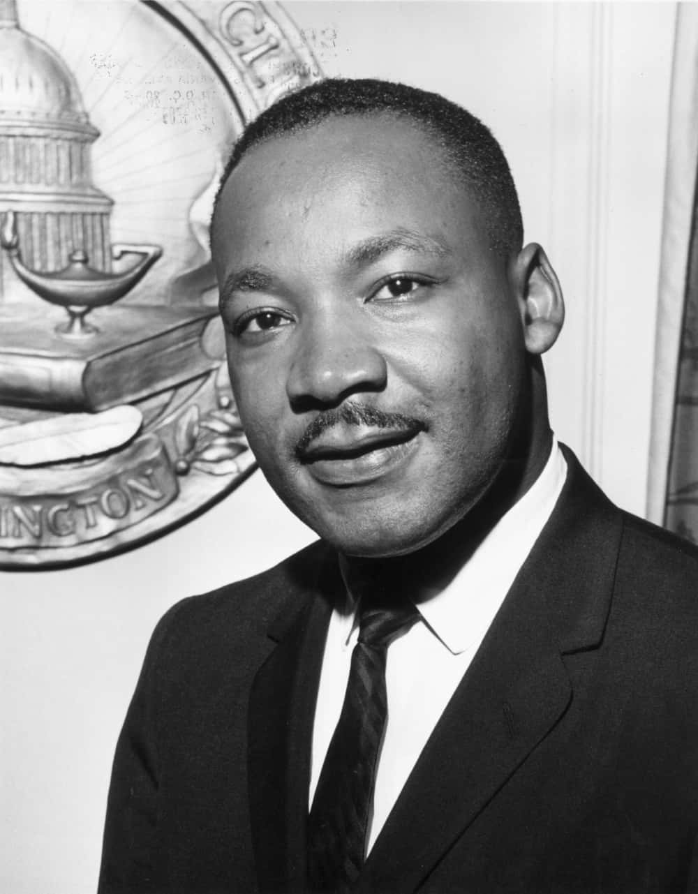 Et sort og hvidt fotografi af en mand i jakkesæt