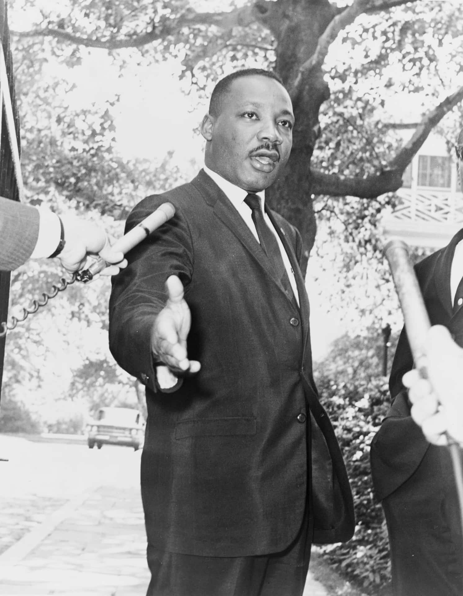 En mand og Martin Luther King Jr. taler med reportere på et pressemøde.