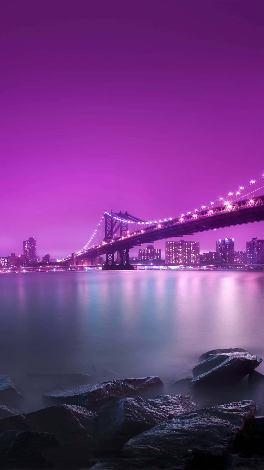 A Purple Sky With A Bridge And Rocks