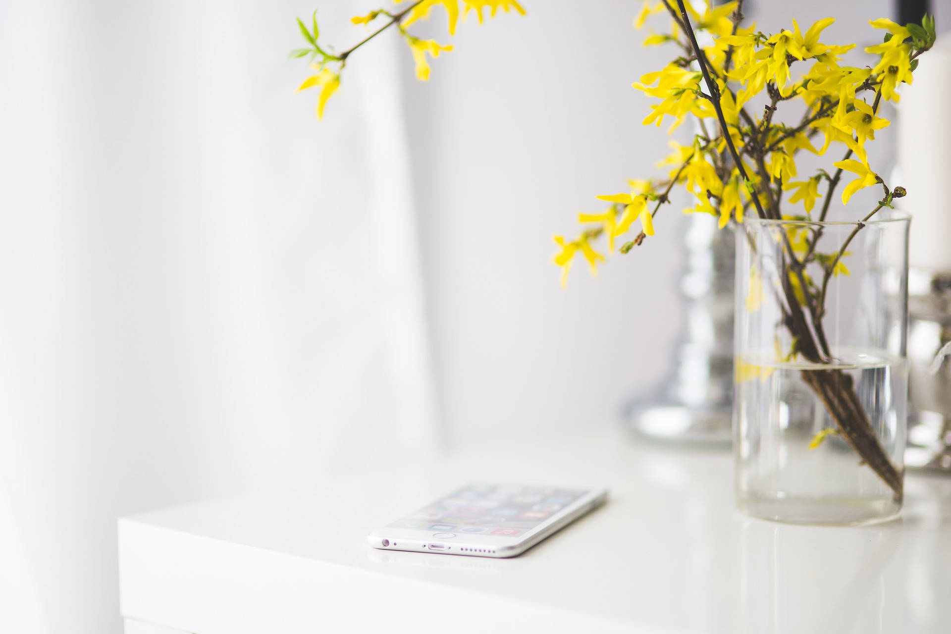 Mobile Phone Beside Yellow Flowers Background