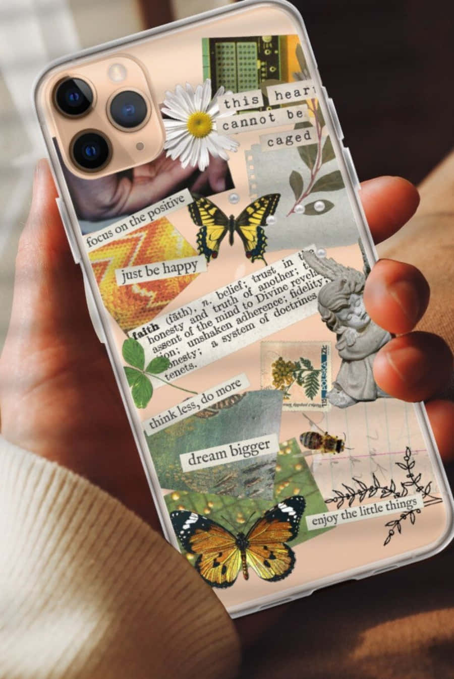 En person, der holder en iPhone-sag med sommerfugle og blomster.