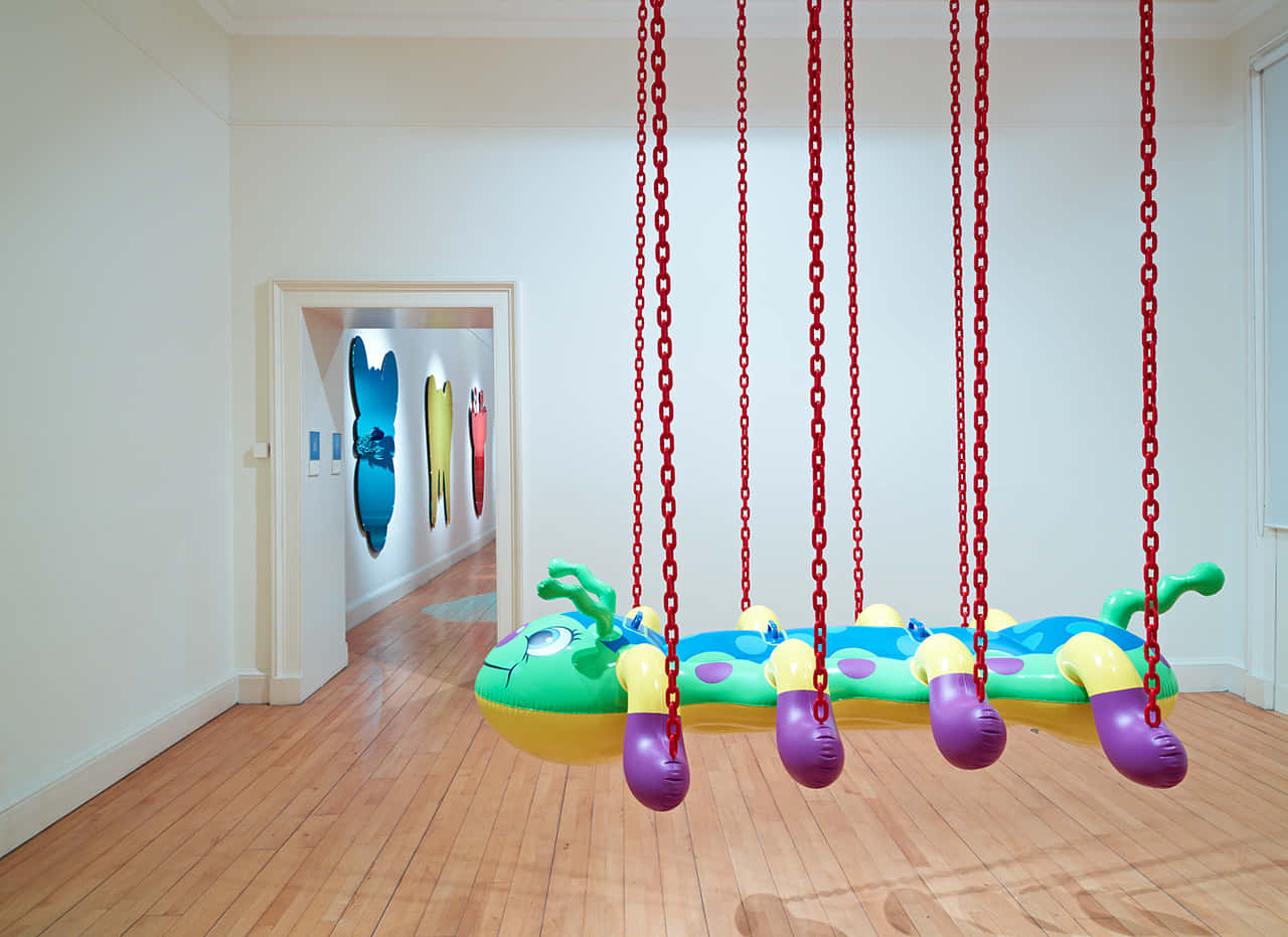 Modern Art Exhibitwith Inflatable Pool Toysand Swings Wallpaper